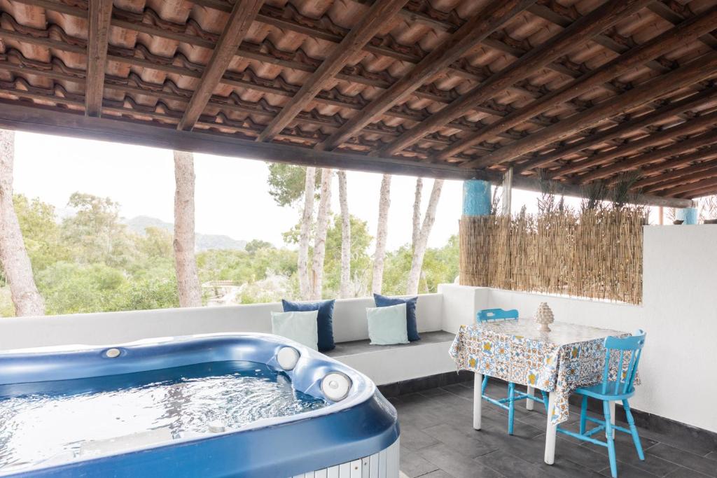 - un bain à remous sur une terrasse avec une table et des chaises dans l'établissement Holiday Eolie Village, à Vulcano