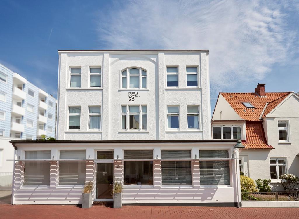 een wit gebouw met een grote witte veranda bij Ferien Domizil 25 in Norderney