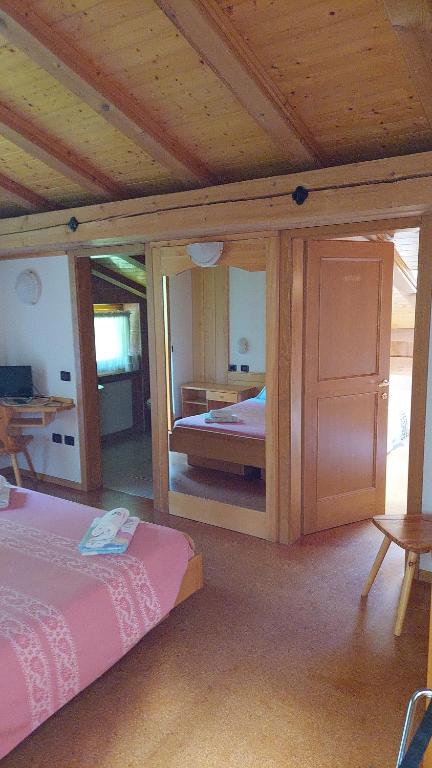 a bedroom with a bed and a wooden ceiling at Albergo Scoiattolo in Tret