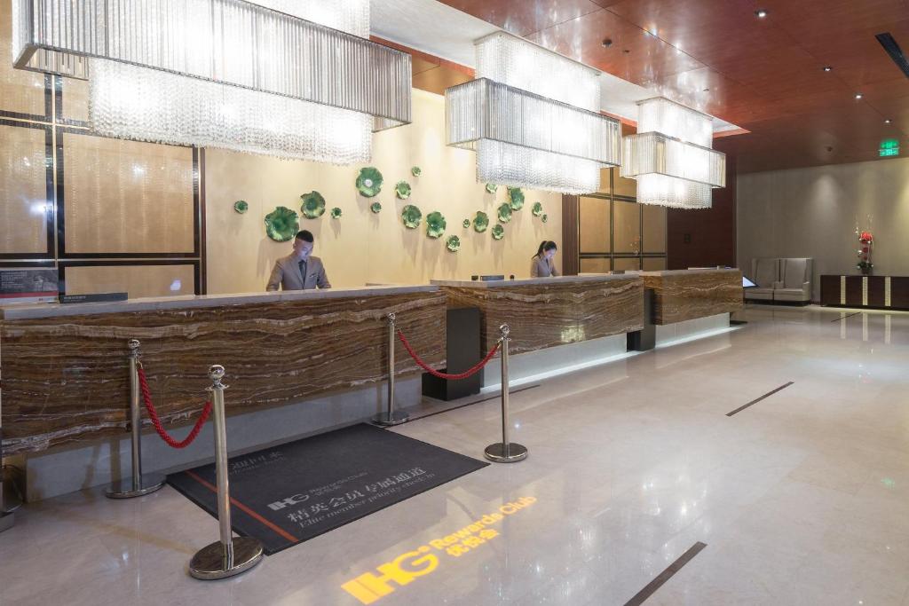 a restaurant with a bar with people standing behind it at Intercontinental Jinan City Center, an IHG Hotel in Jinan