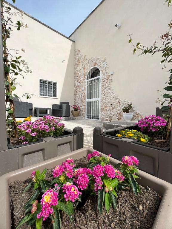 un jardín con flores en un patio en Antica Dimora "Lu suli, Lu mari, Lu jentu", en Monacizzo