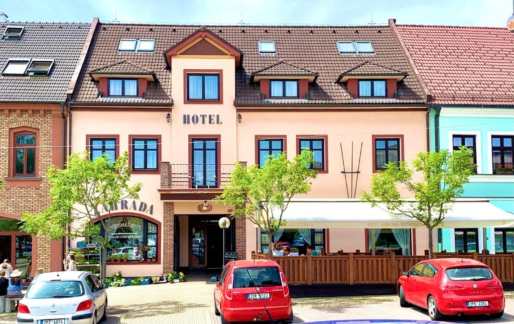 Hotel Bílý Beránek Kralovice في Kralowitz: مبنى فيه سيارات تقف امامه