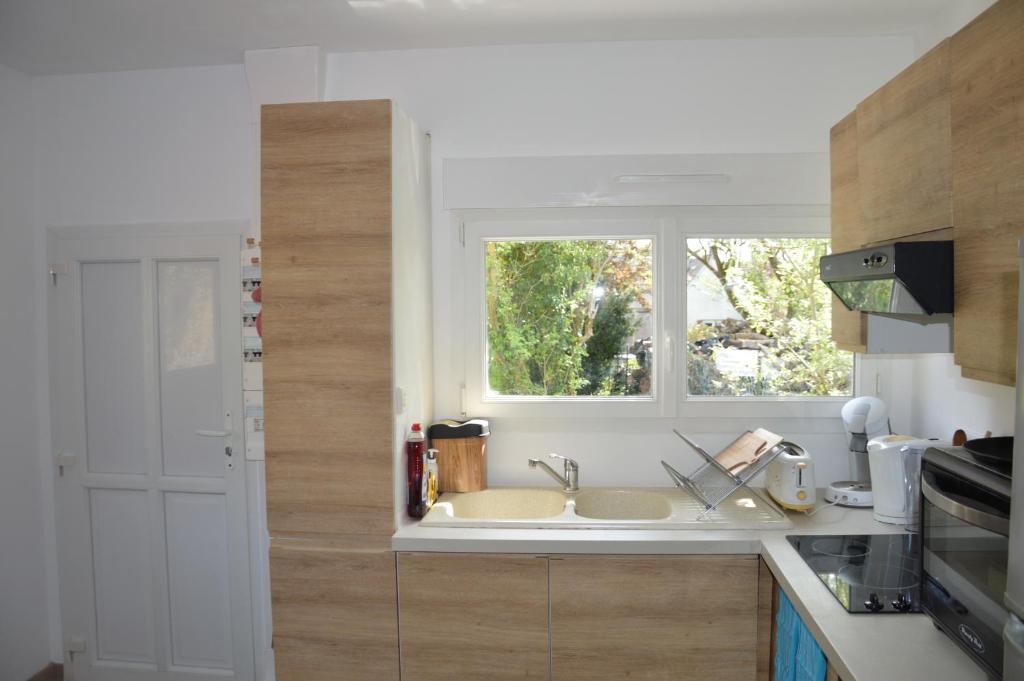 une cuisine avec un évier et une fenêtre dans l&#39;établissement Maisonette Vallée de l&#39;Automne Streaming &amp; Vinyles, 