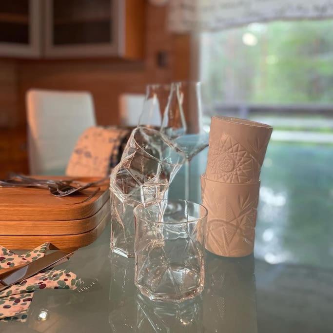 a table with two glass vases and a cup on it at Casa Aura in Aura