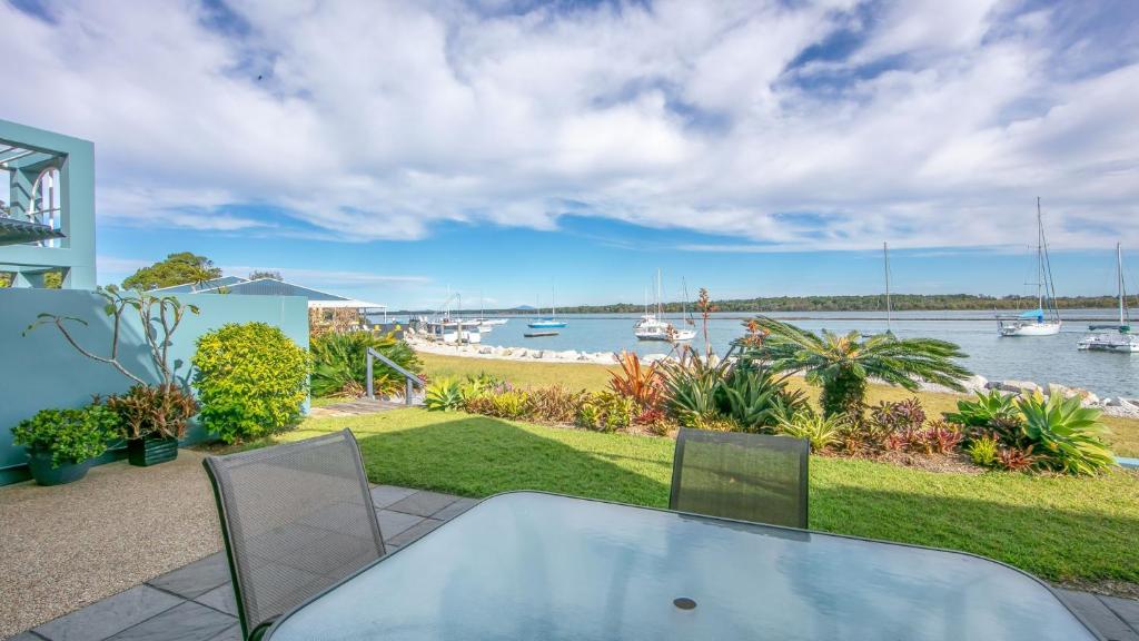 a table and chairs on a patio with a view of the water at Riverview Apartment 2 Block 2 in Iluka