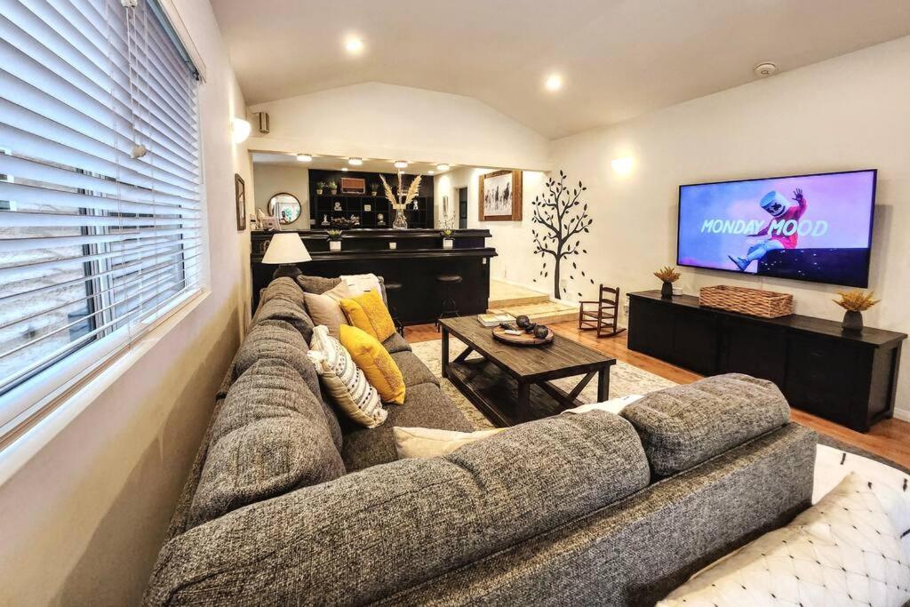 a living room with a large couch and a flat screen tv at 3 BR + Near Venice Beach + Redecorated + Nice Backyard with BBQ in Los Angeles