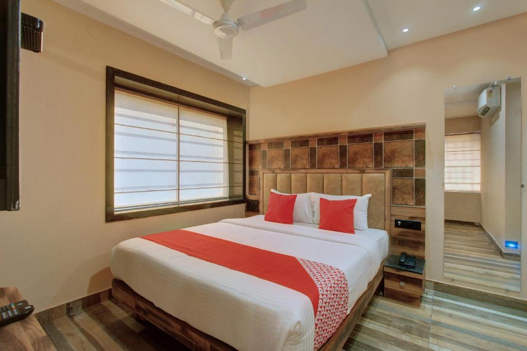 a bedroom with a large bed with red pillows at Laxman Residency in Kulurkudrū