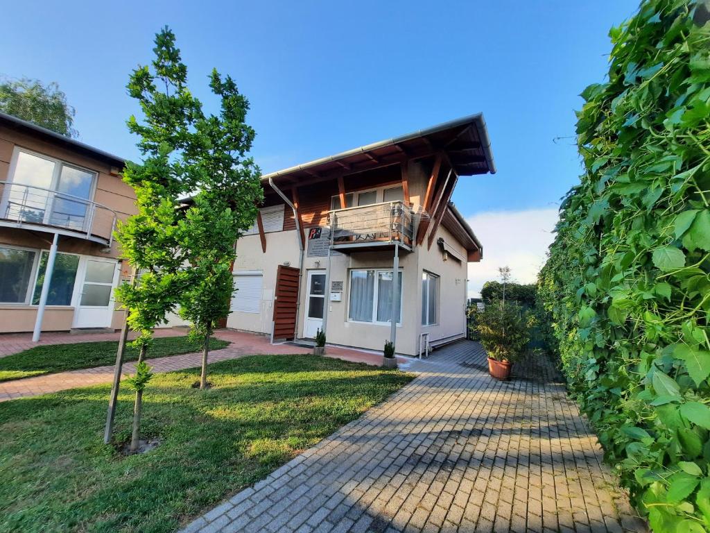 a house with a pathway in front of it at FOKI Apartman in Siófok
