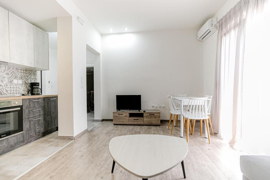 un soggiorno bianco con tavolo e sedie di John luxury apartment a Alexandroupoli