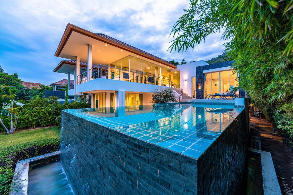 a house with a swimming pool in front of it at Phu Montra Villa with Ocean View in Khao Tao