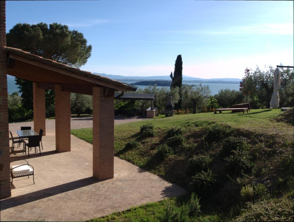 a pavilion with a table and chairs in a park at Antico Casale Tiravento in Passignano sul Trasimeno
