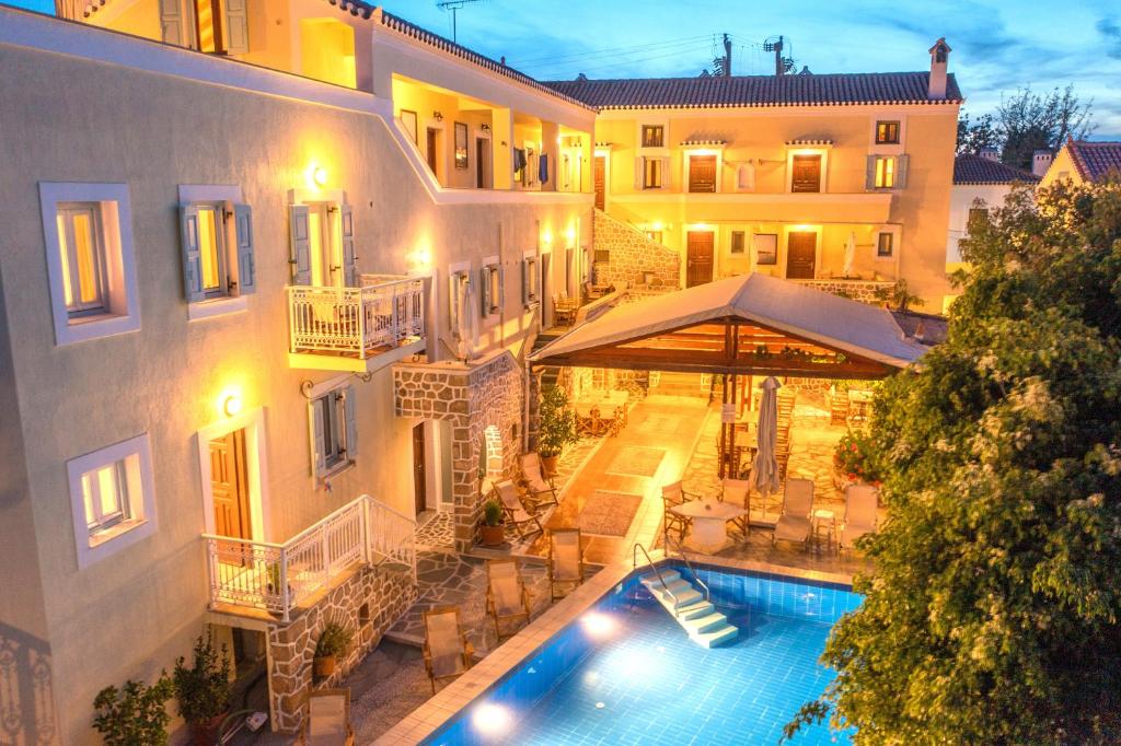 an external view of a hotel with a swimming pool at Kastro Hotel in Spetses