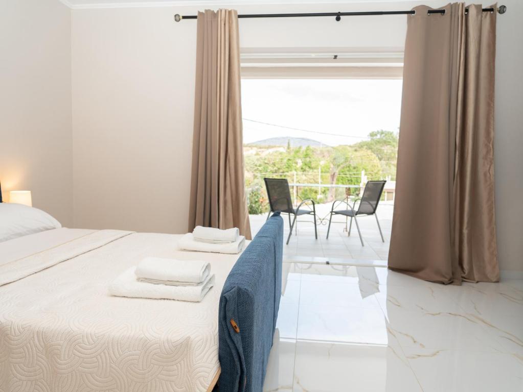 a bedroom with a bed and a large window at ALLAGIANNIS GROUP APARTMENTS in Markopoulo