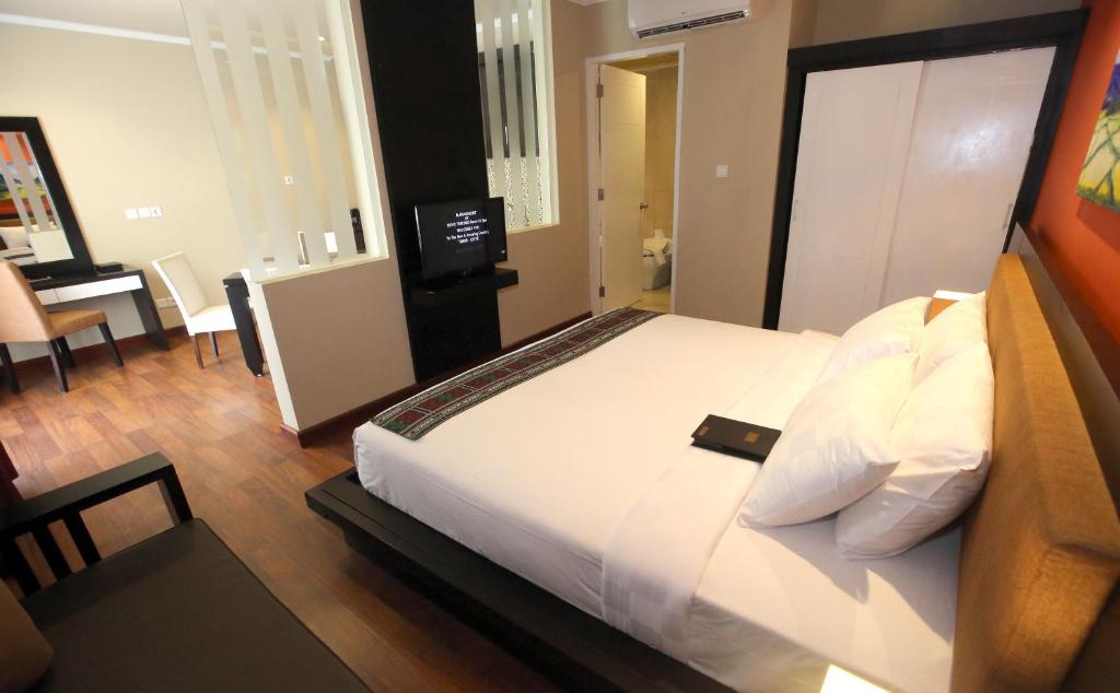 ein Schlafzimmer mit einem großen Bett und einem Schreibtisch in der Unterkunft Novo Turismo Resort & Spa in Dili
