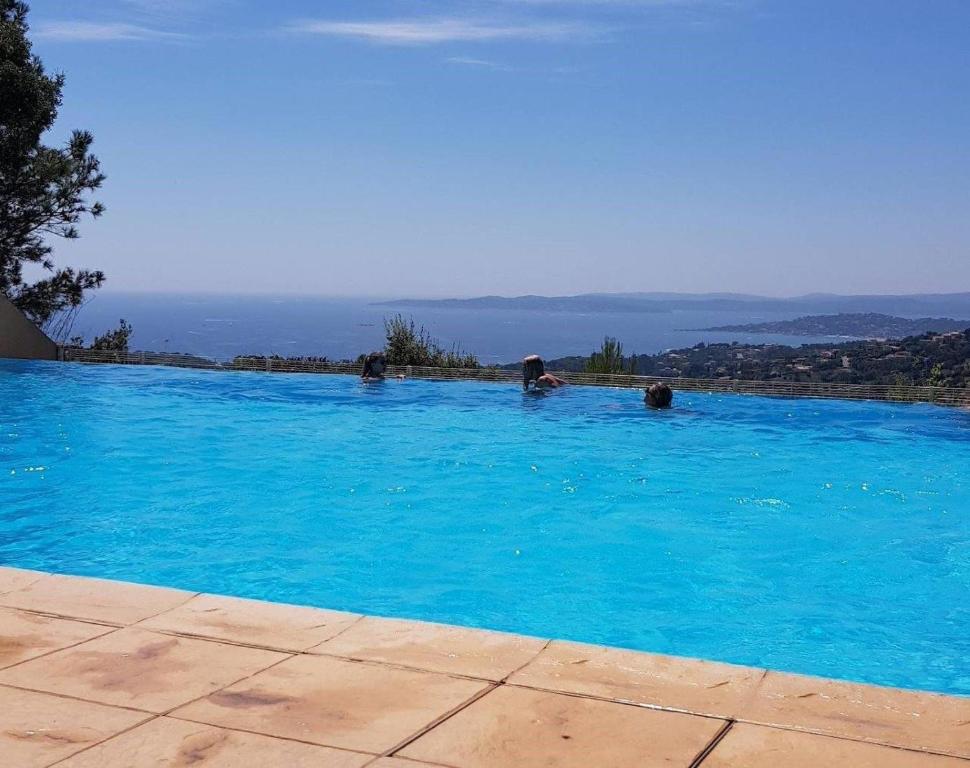 une grande piscine bleue avec des gens dedans dans l'établissement Résidence Belle-Vue à Les Issambres, à Roquebrune-sur Argens