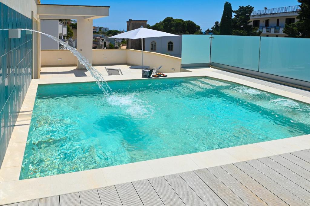 una piscina con una fuente en un edificio en Perle Marine Suite Apartments, en Castro di Lecce