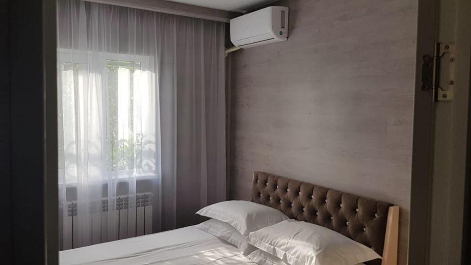 a bedroom with a bed with a window and a bed sidx sidx sidx at Sapar Budget Hotel in Shymkent