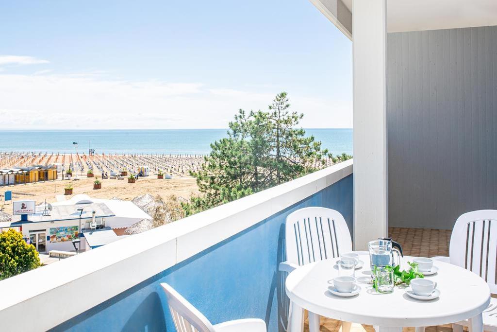 balcone con tavolo, sedie e spiaggia di Columbus Vista Mare a Bibione