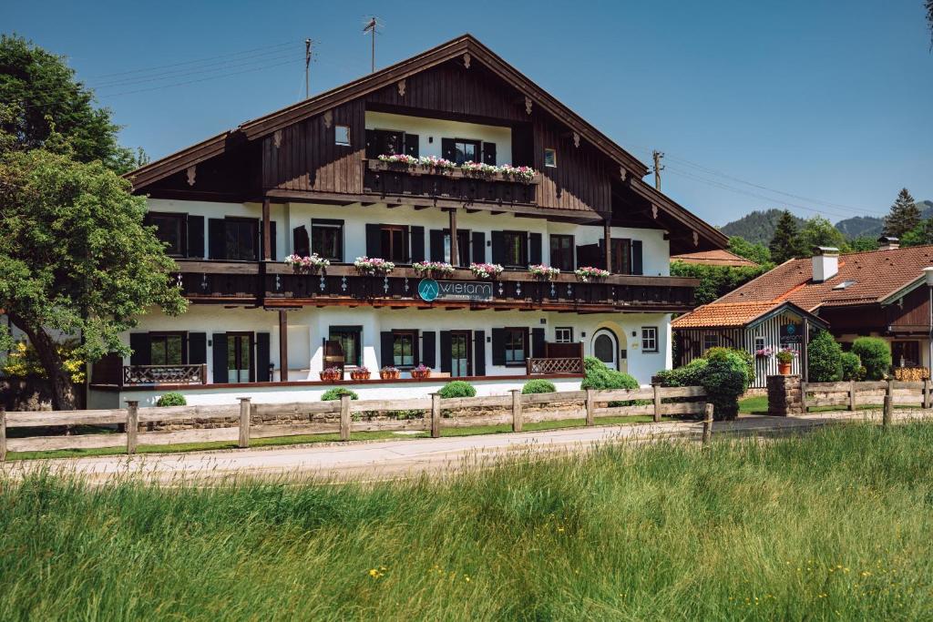 ein großes Haus mit einem Zaun davor in der Unterkunft Wiefarn Apartments - Ferienwohnungen in Bad Wiessee am Tegernsee in Bad Wiessee