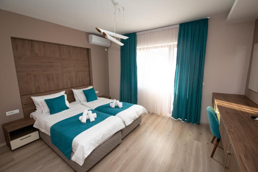 a bedroom with a large bed with two stuffed animals on it at ZARO Apartments in Bitola