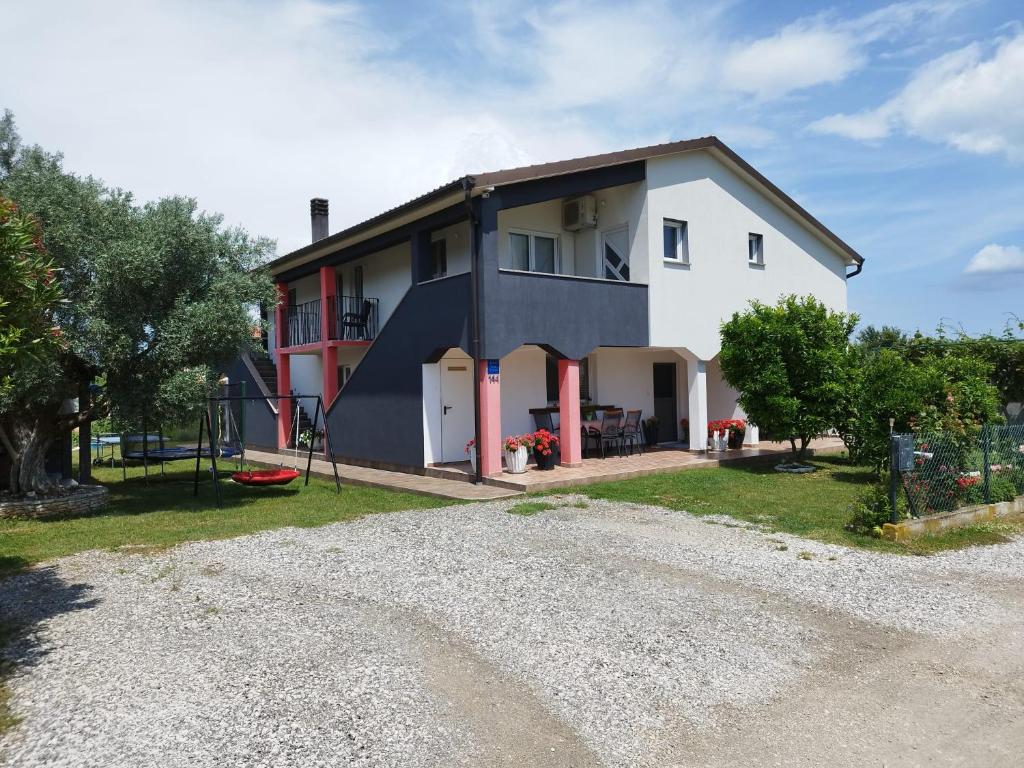 a large white house with a gravel driveway at Marijan in Pula