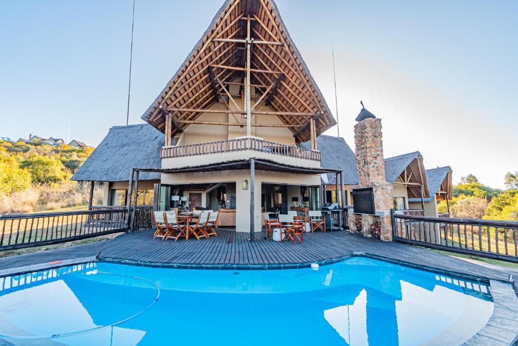 una casa con piscina di fronte a una casa di Kubu Lodge a Mabula