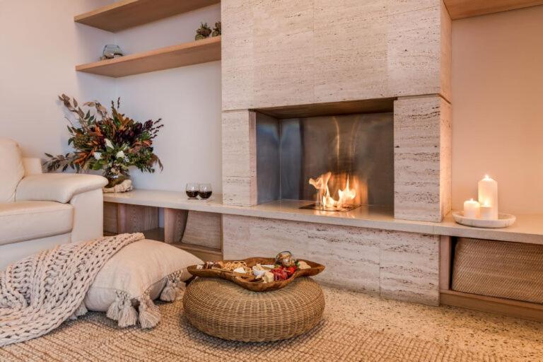 a living room with a fireplace and a couch at Injidup Spa Retreat in Yallingup