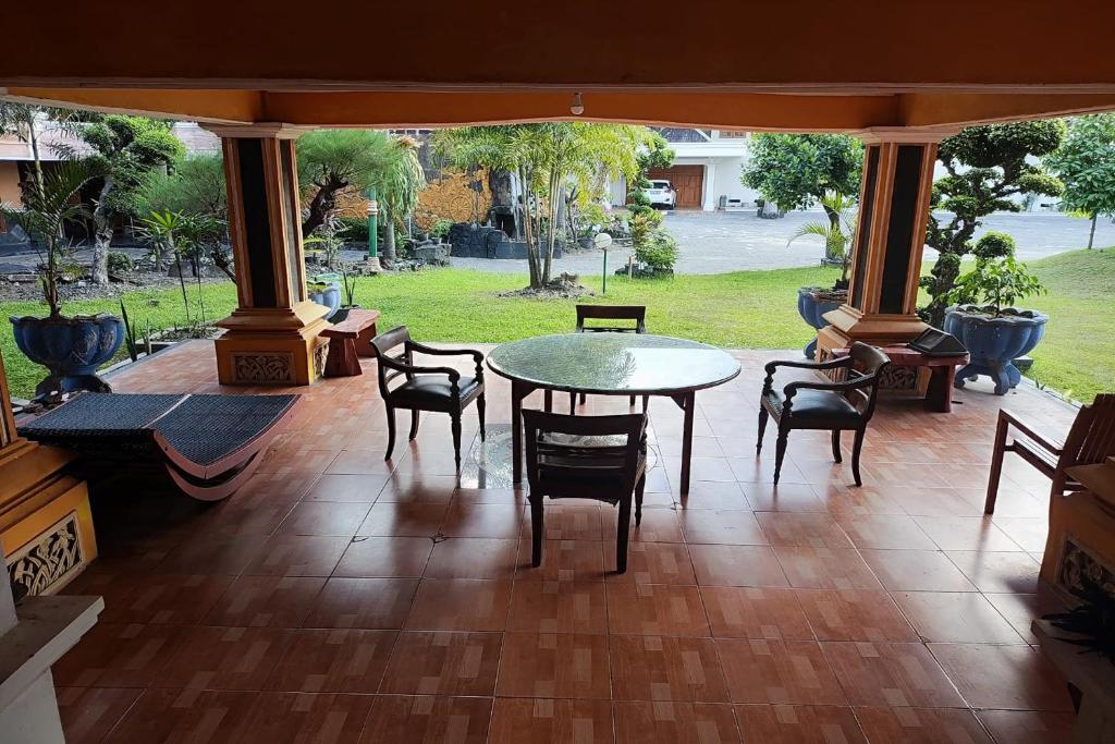 een patio met een tafel en stoelen op een veranda bij Hotel Bima in Klaten