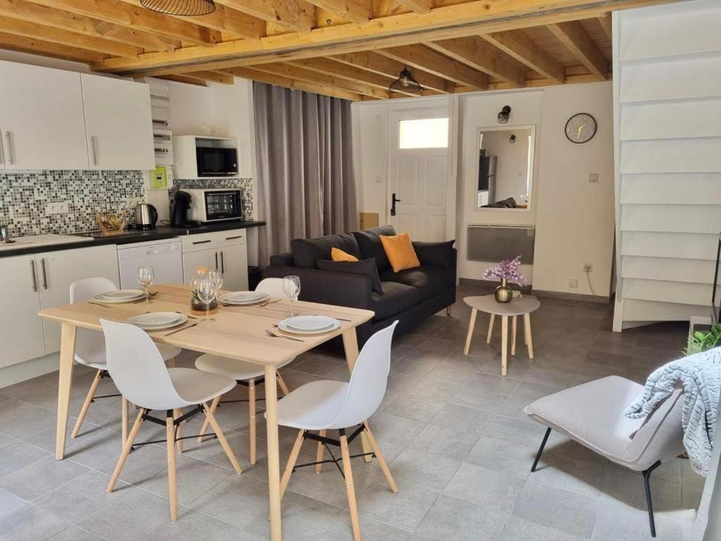 eine Küche und ein Wohnzimmer mit einem Tisch und Stühlen in der Unterkunft Maison avec Extérieur - Stationnement Gratuit in Périgueux