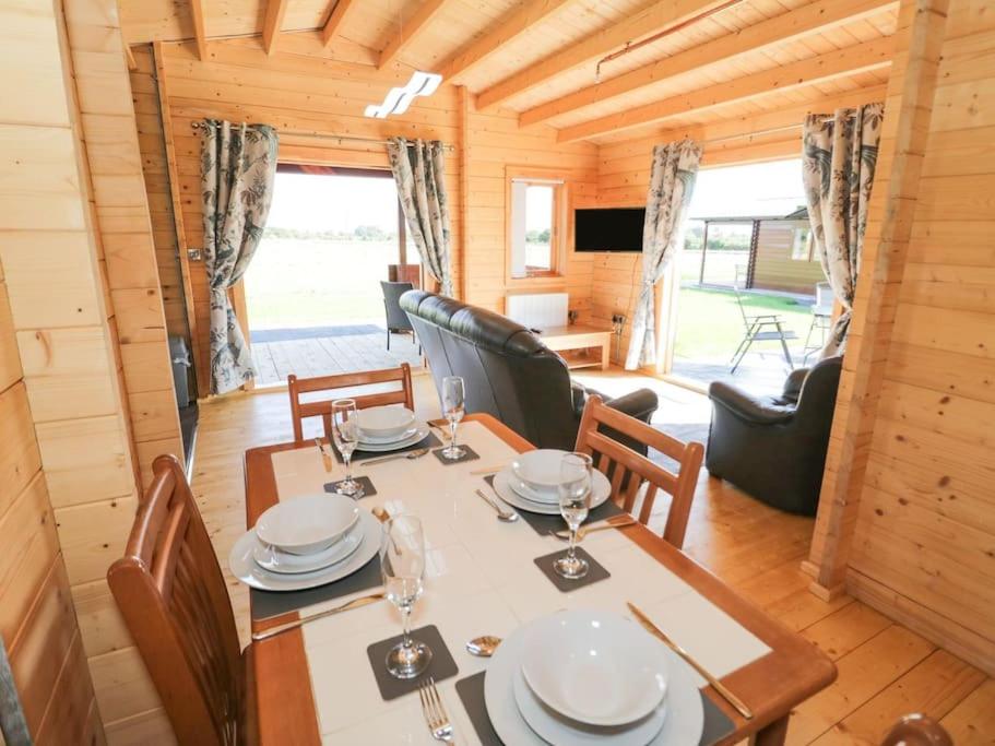 a dining room with a table and chairs at Ty Will, Parc Y Fronwen in Newborough