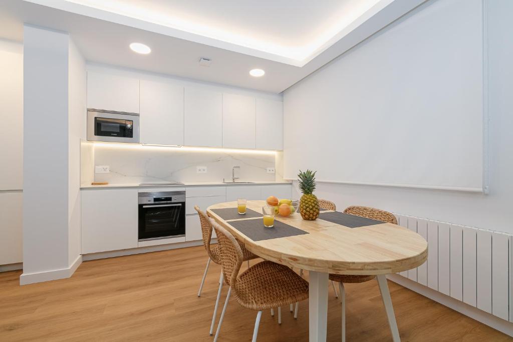 a kitchen and dining room with a wooden table and chairs at LUXURY SILGAR in Sanxenxo