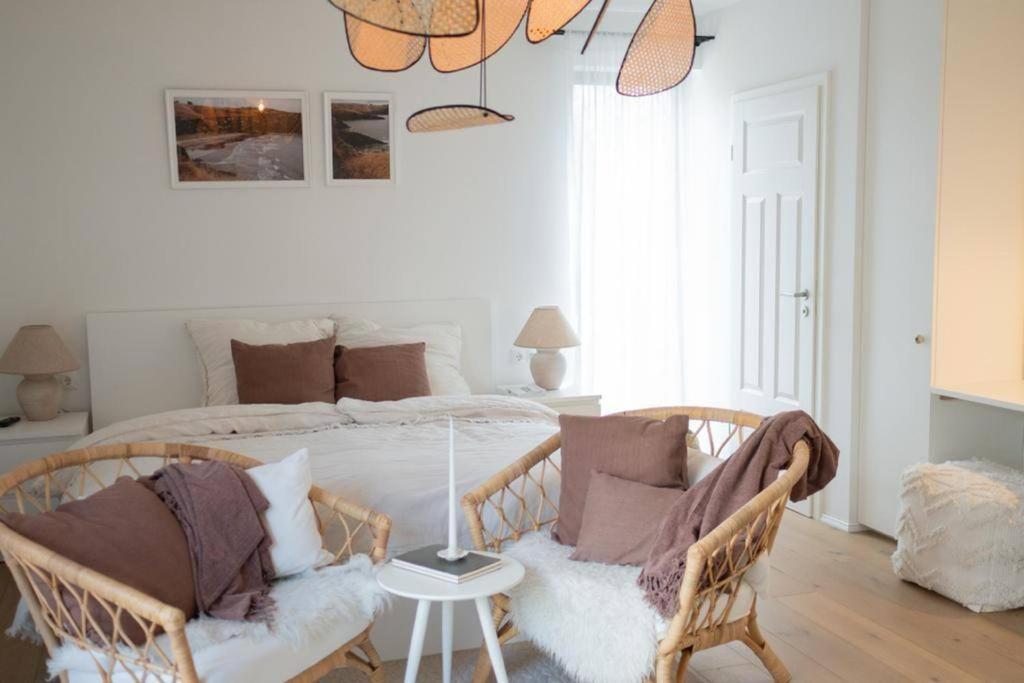Oberkotzau的住宿－1-Zimmer-Appartement, beste Lage，一间卧室配有一张带两张藤椅的床