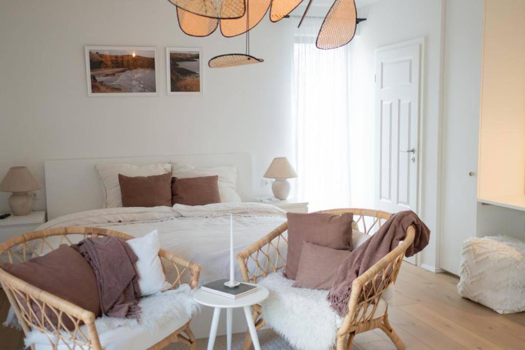 a bedroom with a bed with two wicker chairs at 1-Zimmer-Appartement, beste Lage in Oberkotzau