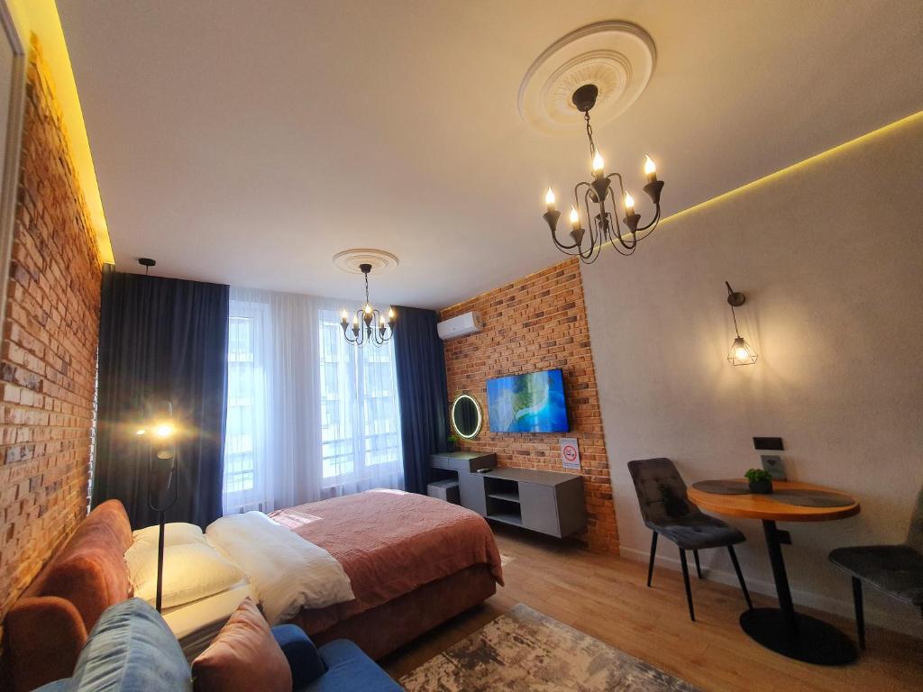 a bedroom with a bed and a table and a couch at VIP studio in the center of Kyiv residential complex "Yaroslavov Grad" in Kyiv