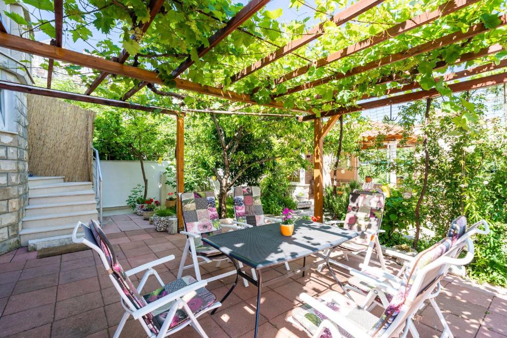 a patio with a table and chairs under a pergola at Apartments & Rooms V&M in Dubrovnik