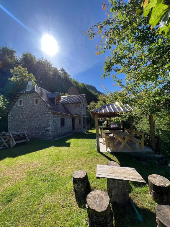 a picnic table in the yard of a house at Guest House Gjelaj in Theth