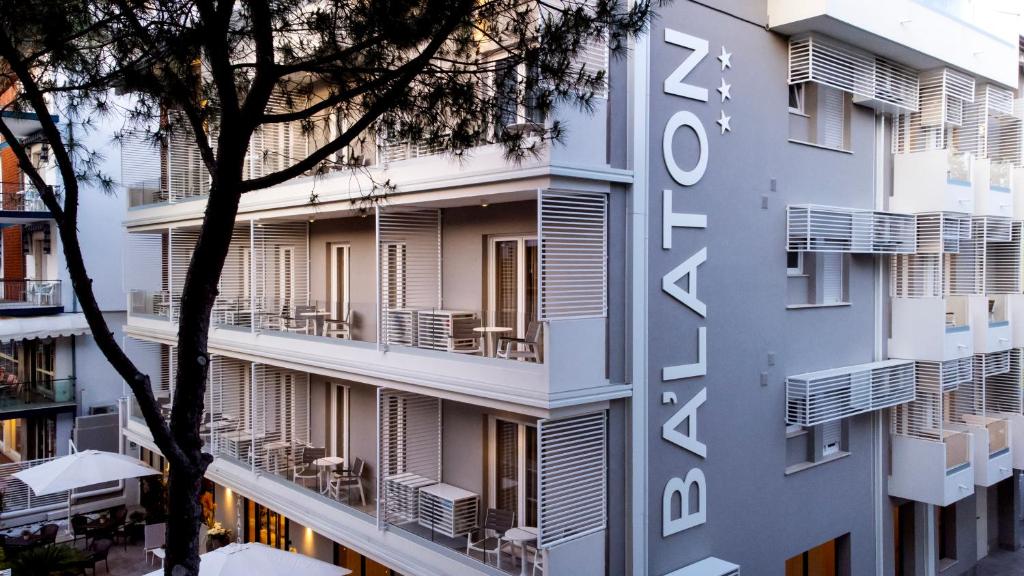 リッチョーネにあるHotel BalatonのACホテルを読み取る看板のある建物