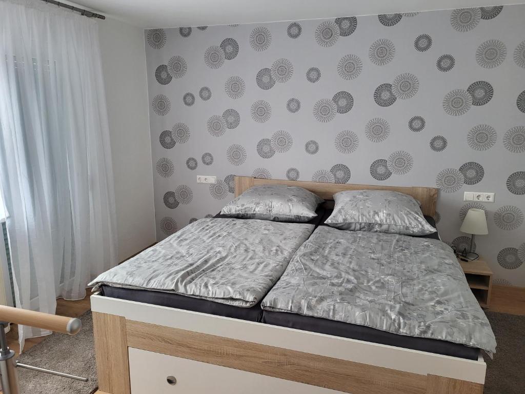 Un dormitorio con una cama y una pared con lunares. en Ferienwohnung Hanna, en Stockach