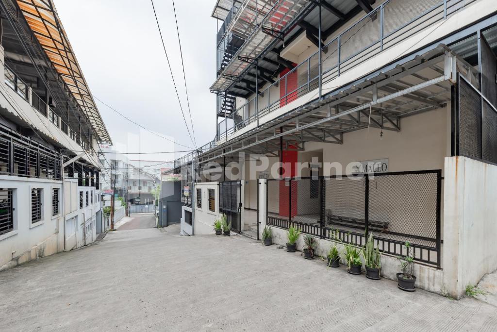 an empty courtyard of a building with potted plants at Maleo Residence Bandung Mitra RedDoorz in Bandung