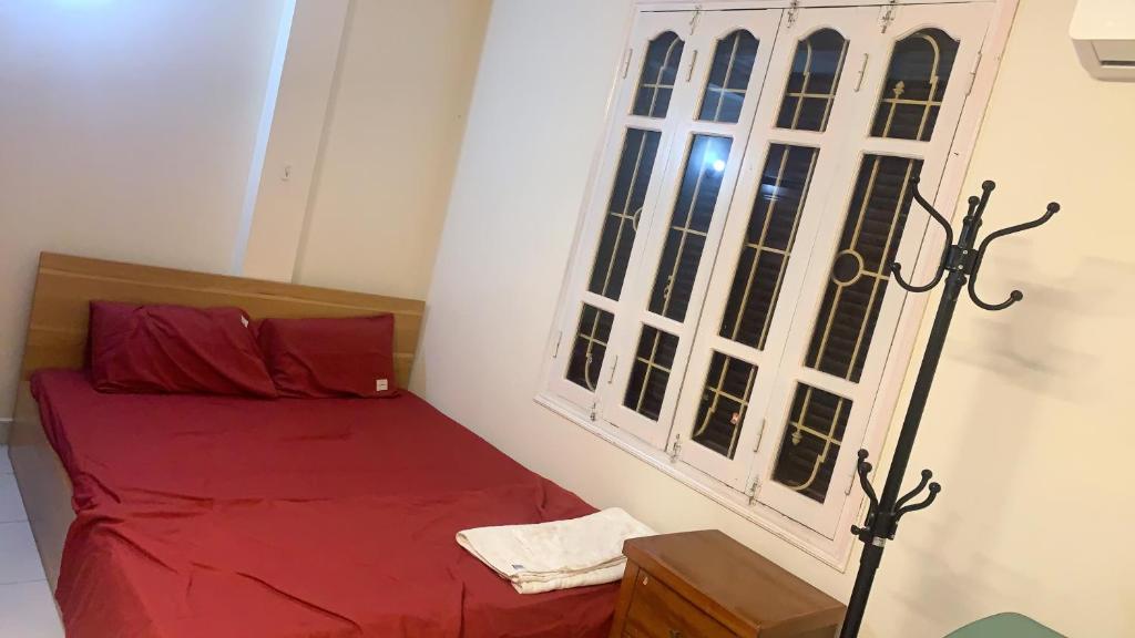 - une chambre avec un lit rouge et une fenêtre dans l'établissement Bong House 5, à Hanoï