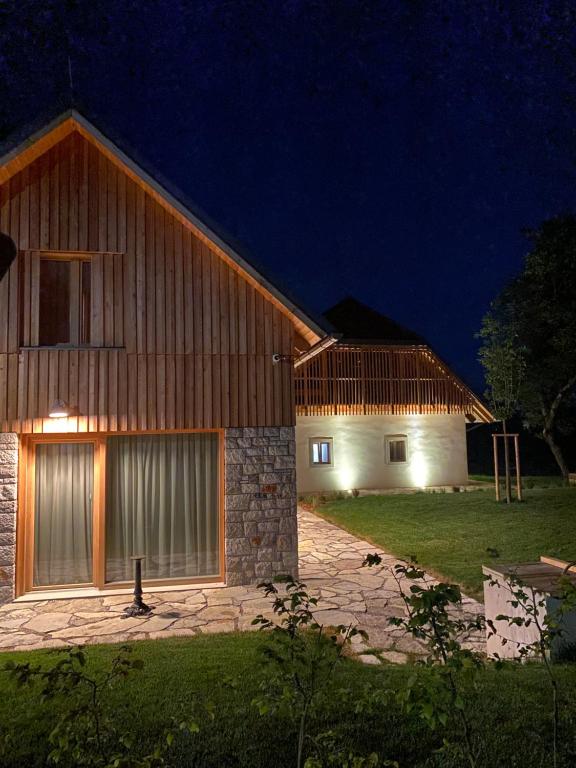 dwie stodoły w nocy z włączonymi światłami w obiekcie PIRA HOTEL w mieście Postojna