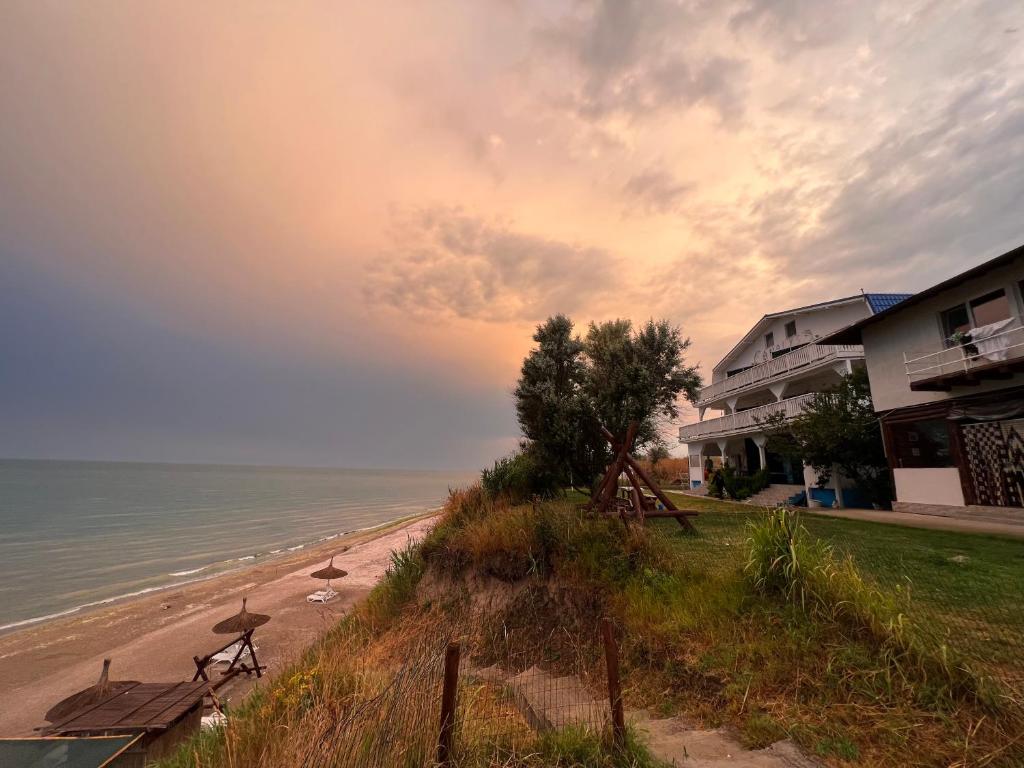 a beach with benches and a building and the ocean at Casa Analys in Douăzeci şi Trei August