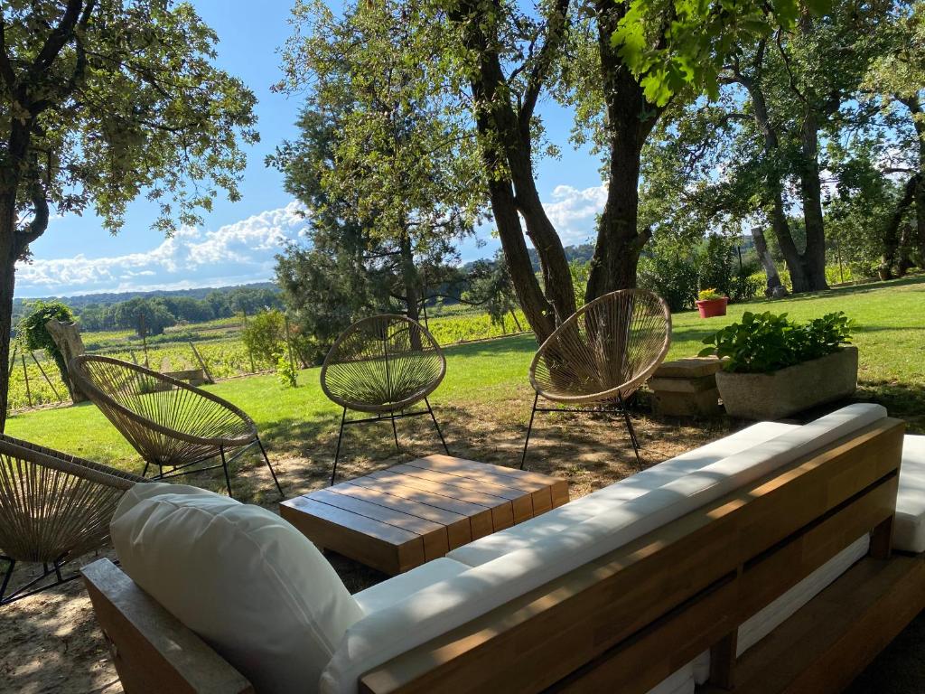 d'une terrasse avec des chaises et un banc offrant une vue. dans l'établissement Le Clos, à Courthézon