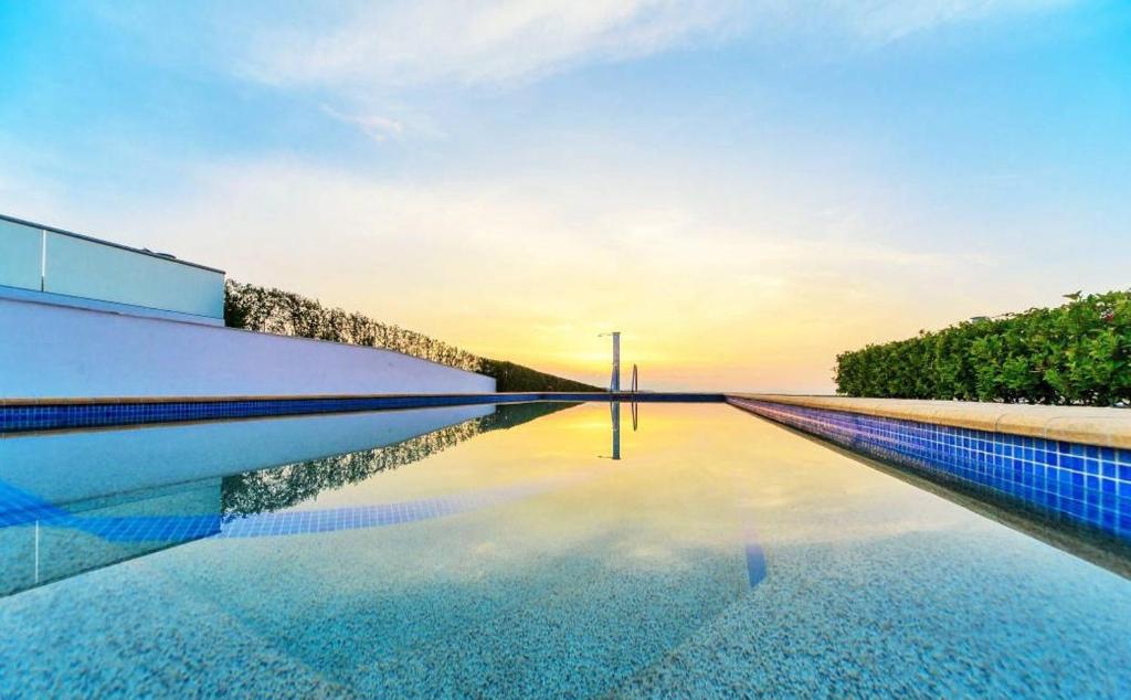 una piscina con il tramonto sullo sfondo di Sunset Villa a Hanioti
