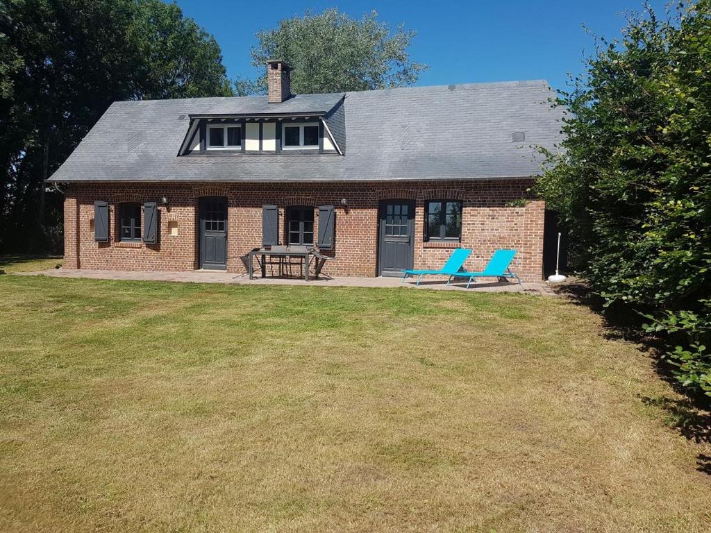 a brick house with two blue chairs in the yard at Maison Campagne Dix Kilomtres De in Hautot-lʼAuvray