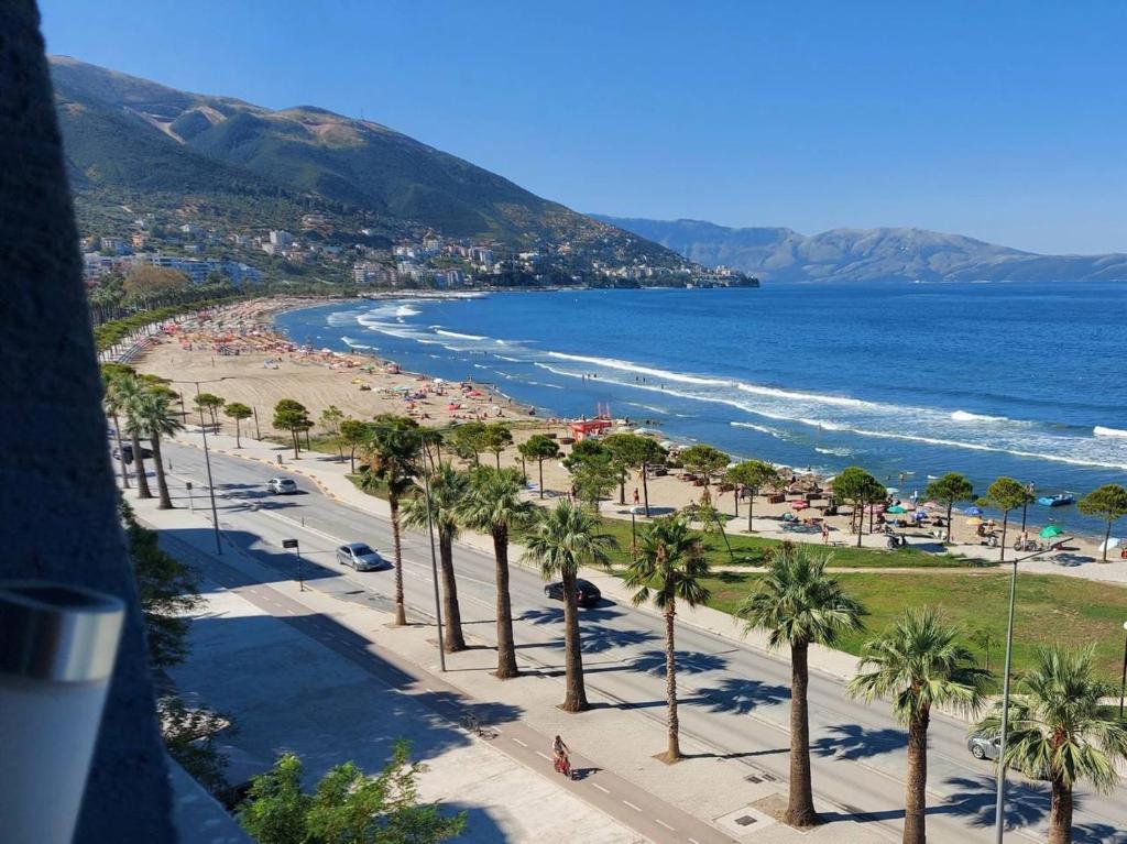Blick auf einen Strand mit Palmen und das Meer in der Unterkunft Apartments Vlora Holidays in Vlorë