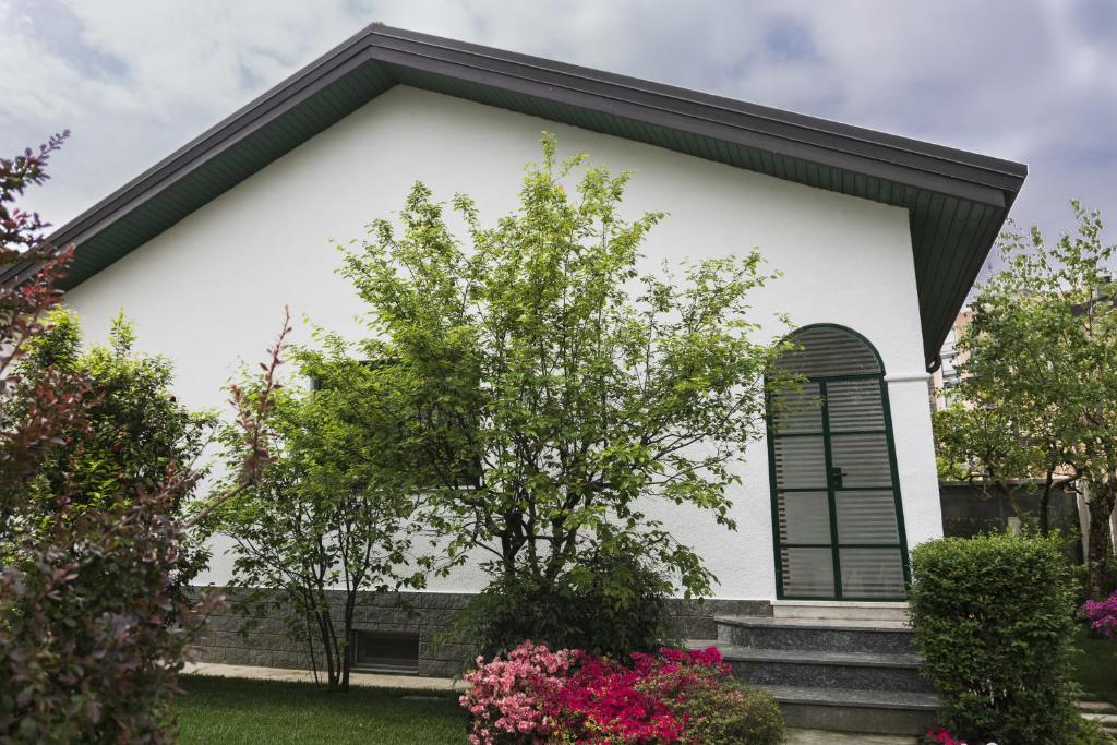 Biały dom z czarnym oknem i kwiatami w obiekcie Il giardino di Fiorina w mieście Novate Milanese