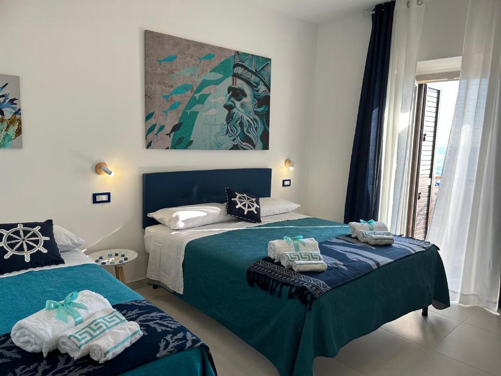 a bedroom with two beds and a painting on the wall at VistAmare - Fuscaldo in Marina di Fuscaldo