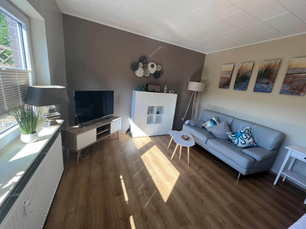 a living room with a blue couch and a television at Hooge Hörn Bantje Wohnung 3 in Borkum