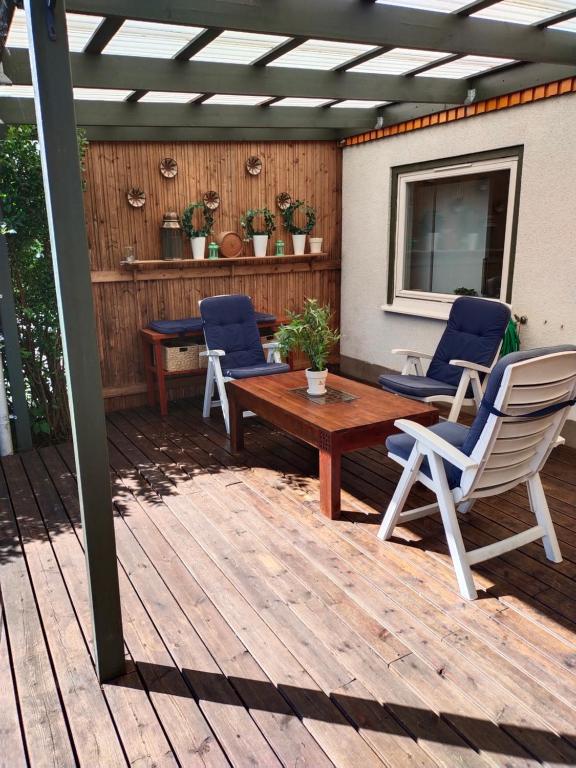 eine Terrasse mit einem Holztisch und Stühlen auf einer Terrasse in der Unterkunft Torstuna in Stockholm